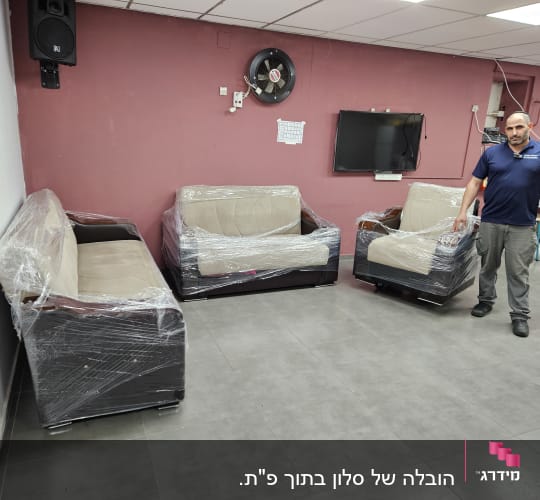 ספות עטופות בניילון בחדר עם קירות ורודים